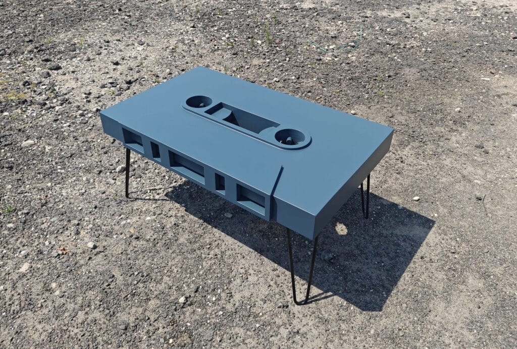 Moderne petrol blauw gespoten design tafel in de unieke vorm van een cassettebandje. Dit strakke meubel is gemaakt van kwalitatief MDF en professioneel lakwerk/spuitwerk. Een op maat gemaakt eyecatcher meubelstuk van meubelmakerij Glenn Ederveen, geëxposeerd in Maastricht.