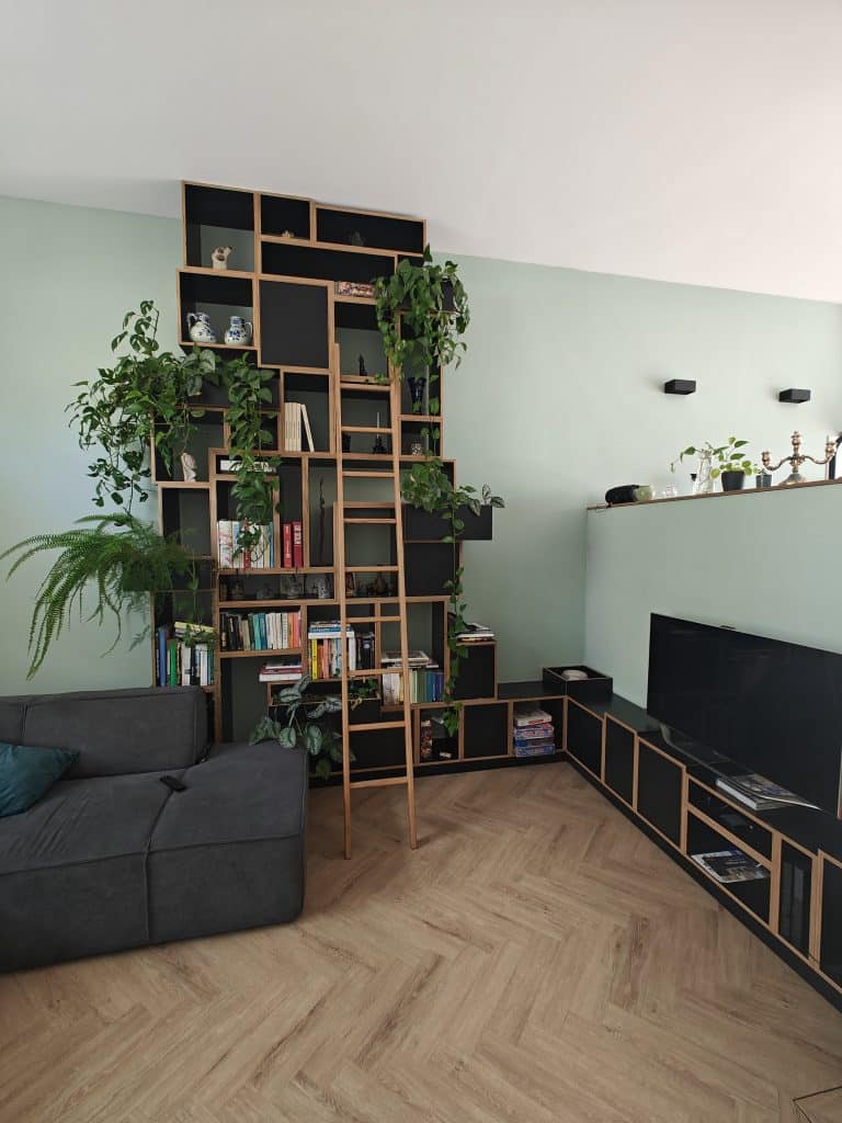 Zwarte vakkenkast op maat met geïntegreerde plantenpotten, tv-meubel en ladder